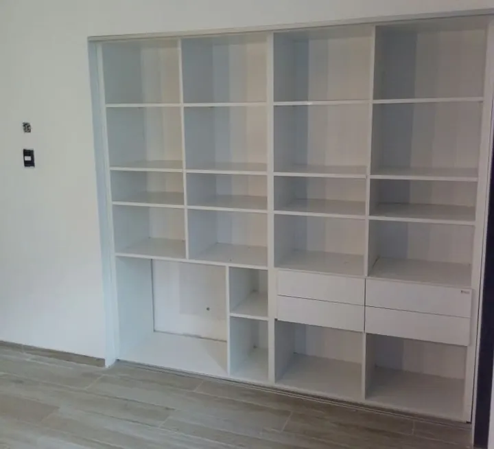 Mueble de guardado blanco a medida que ocupa un nicho de pared a pared, fabricado en nuestro taller de General Roca
